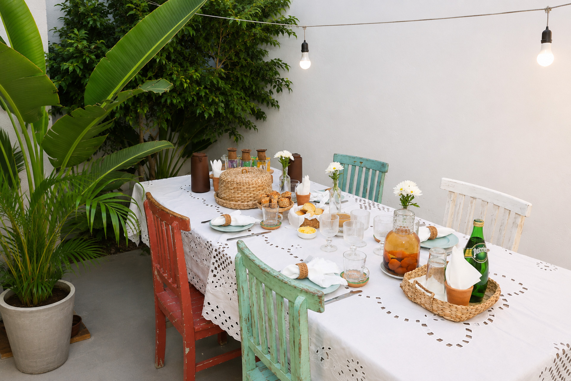 Mesa de café da manhã posta com pães, frutas e flores